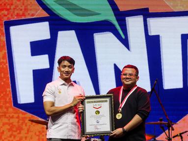 Senior Manager Museum Rekor Indonesia (MURI), Triyono (kiri) menyerahkan piagam ke Frontline Brand Manager The Coca-Cola Company Muhammad Maulana Soesetyo saat acara KapanLagi Pensi Bareng Fanta 2025 di Gelanggang Olahraga (GOR) atau Gelanggang Mahasiswa Soemantri Brodjonegoro, Jakarta, Sabtu (28/6/2025). (Liputan6.com/Herman Zakharia)