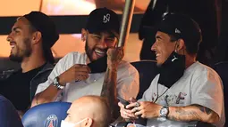 Pemain PSG, Neymar tertawa saat menyaksikan pertandingan antara PSG melawan Metz pada laga Liga Prancis di Stadion Parc des Princes, Kamis (17/9/2020). Akibat pertikaian di laga melawan Marseille, Neymar dihukum larangan dua pertandingan. (AFP/Franck Fife)