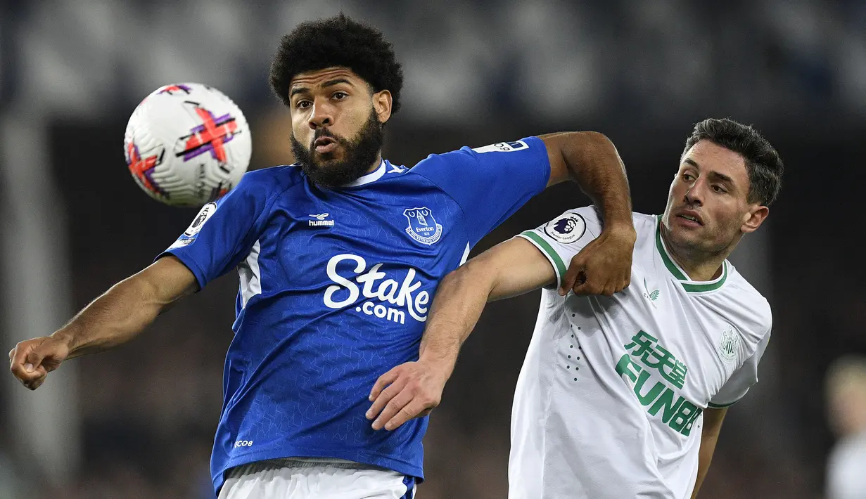 Pemain Everton, Ellis Simms (kiri) berebut bola dengan pemain Newcastle United, Fabian Schar pada laga pekan ke-33 Liga Inggris 2022/2023 di Goodison Park, Liverpool, Jumat (28/04/2023) dini hari WIB. The Magpies sukses menghajar tuan rumah dengan skor 4-1. (AFP/Oli Scarff)
