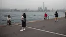 Orang-orang mengambil foto di dermaga umum di sebelah Pelabuhan Victoria di Hong Kong (3/3). Pelabuhan Victoria adalah sebuah pelabuhan bentang alam alami yang terletak antara Pulau Hong Kong dan Kowloon di Hong Kong. (AFP Photo/Dale De La Rey)