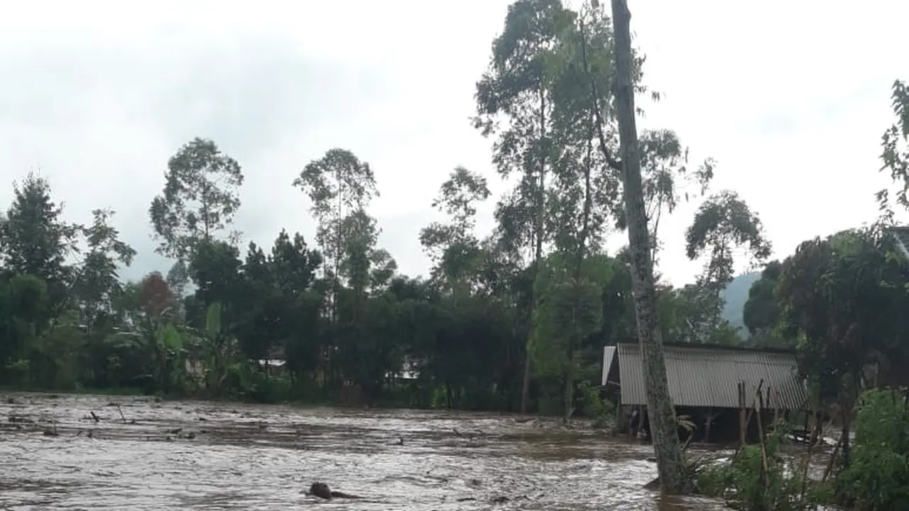 Nampak warga dan aparat TNI tengah membersihkan lumpur akibat sapuan banjir bandang
