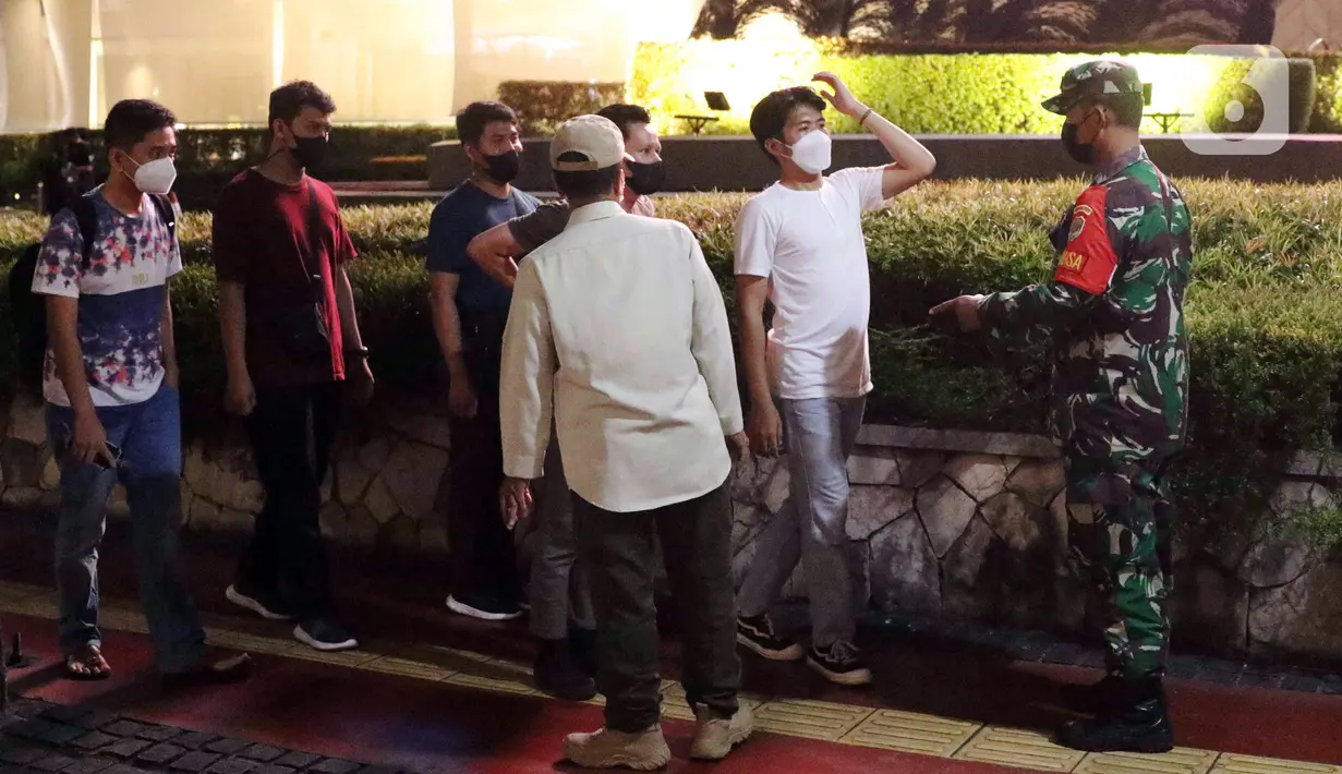 Tentara melakukan pembubaran terhadap warga yang berkerumun di kawasan Bundaran HI, Jakarta, Jumat (31/12/2021). Untuk mencegah penyebaran COVID-19, petugas gabungan melakukan pembubaran aktivitas warga di malam Tahun Baru. (Liputan6.com/Angga Yuniar)
