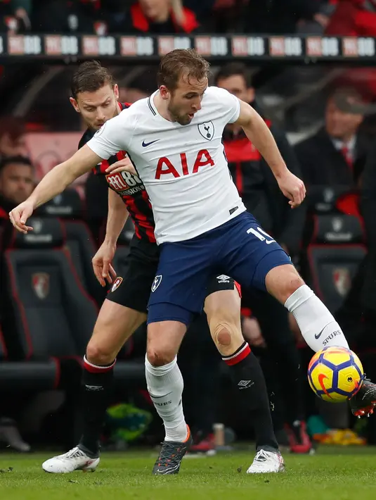 Penyerang Harry Kane berusaha mengontrol bola dari hadangan pemain Bournemouth saat bertanding di Liga Inggris di Stadion Vitalitas (11/3). Pergelangan kaki kanan Kane tertekuk saat tabrakan dengan kiper Asmir Begovic. (AFP Photo/Adrian Dennis)