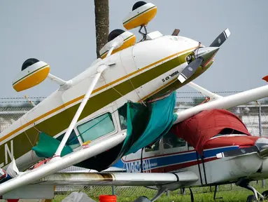 Sebuah pesawat terbalik kemungkinan karena tornado yang dihasilkan dari Badai Ian di Bandara Perry Utara, Pembroke Pines, Florida, 28 September 2022. Kecepatan Badai Ian meningkat saat mendekati daratan di sepanjang pantai barat daya Florida. (AP Photo/Wilfredo Lee)