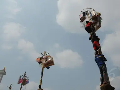 Sejumlah orang berusaha menggapai hadiah dalam lomba panjat pinang di kawasan Tugu Monas, Jakarta, (31/8/2014). (Liputan6.com/Helmi Fithriansyah)
