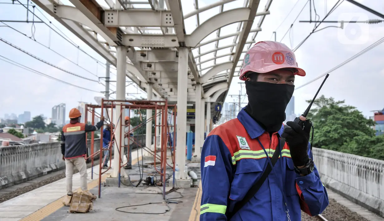 Petugas keamanan berkomunikasi menggunakan radio saat mengawasi laju kereta yang akan melintas di Stasiun Matraman, Jakarta Timur, Kamis (23/12/2021). BTPWJB terus mengebut pembangunan Stasiun Matraman yang ditargetkan dapat beroperasi pada 2022 mendatang. (merdeka.com/Iqbal S. Nugroho)
