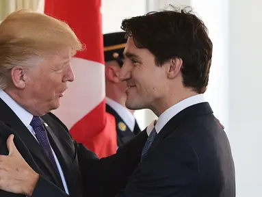 Presiden Amerika Serikat (AS), Donald Trump menyambut kedatangan PM Kanada, Justin Trudeau di Gedung Putih, Washington, Senin (13/2). Tiba di Gedung Putih, sang PM Kanada langsung disambut oleh Trump dengan salam yang hangat. (MANDEL NGAN/AFP)