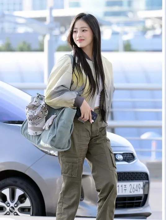 Minji New Jeans tampil boyish dengan crop top dan cargo pants. Minji lengkapi outfitnya dengan bomber jacket [@minji_nwjns]