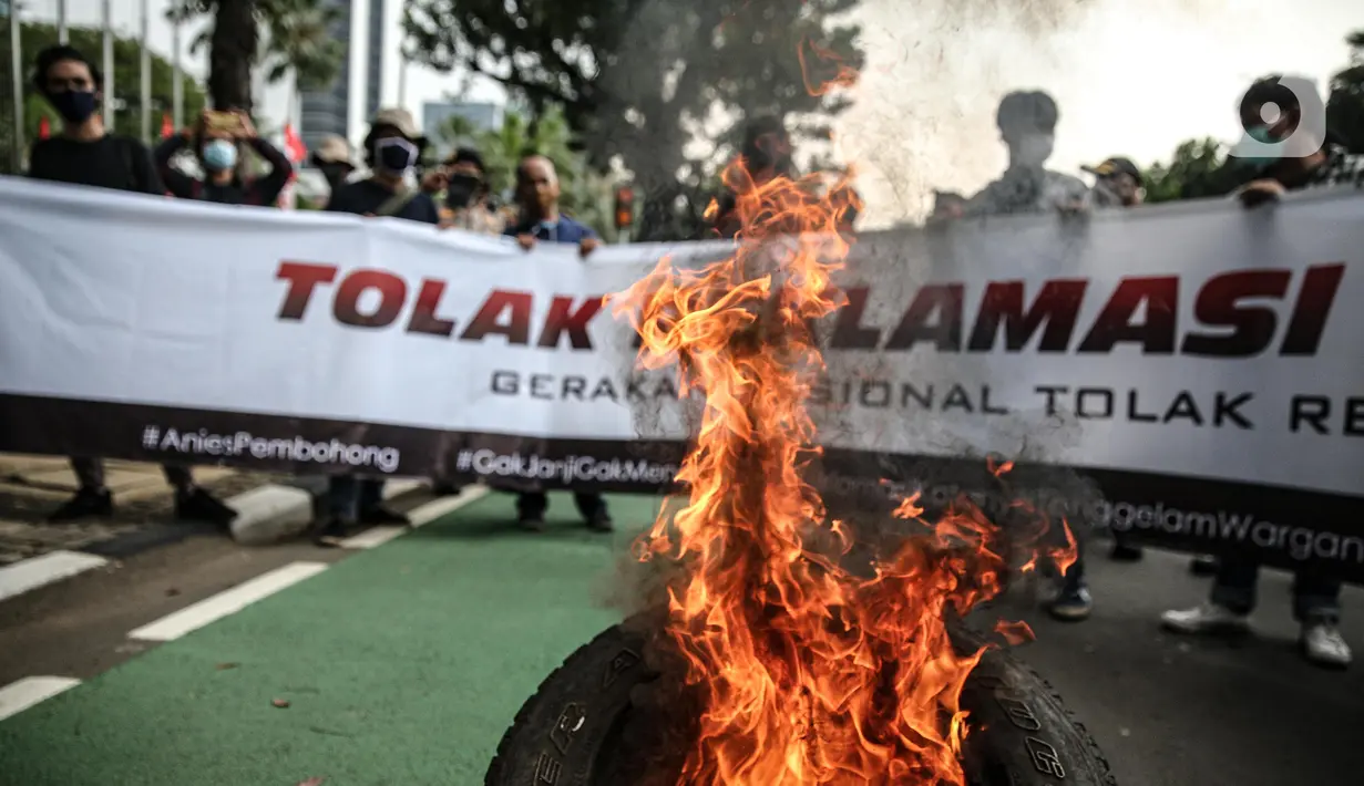 Massa yang tergabung dalam gerakan nasional tolak reklamasi (Gentar) membakar ban saat aksi didepan Gedung Balaikota, Jakarta, Rabu (8/7/2020). Reklamasi Pantai Ancol dianggap sebagai bentuk perampasan pantai publik atas akses masyarakat nelayan pesisir Jakarta.  (Liputan6.com/Faizal Fanani)