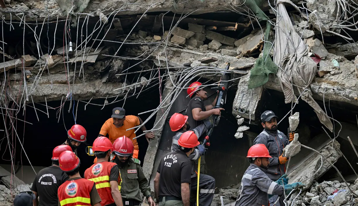 Otoritas kesehatan setempat terus memperbarui data jumlah korban luka maupun korban jiwa seiring dengan berlanjutnya proses evakuasi di lapangan. Tampak dalam foto, petugas penyelamat mencari di tengah reruntuhan setelah kebakaran besar di sebuah pusat perbelanjaan di Karachi pada Senin 19 Januari 2026. (Asif HASSAN/AFP)