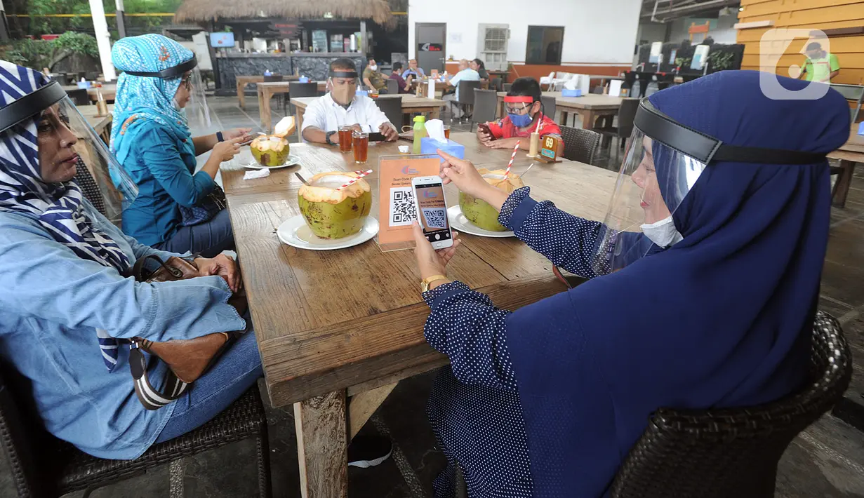 Pelayan mengenakan pelindung wajah saat melayani pengunjung di Restoran Bandar Djakarta, Alam Sutra, Tangerang Selatan, Banten, Rabu (10/6/2020). Tangerang dan Tangerang Selatan menjalankan PSBB transisi menuju kenormalan baru dengan menerapkan protokol kesehatan COVID-19. (merdeka.com/Arie Basuki)