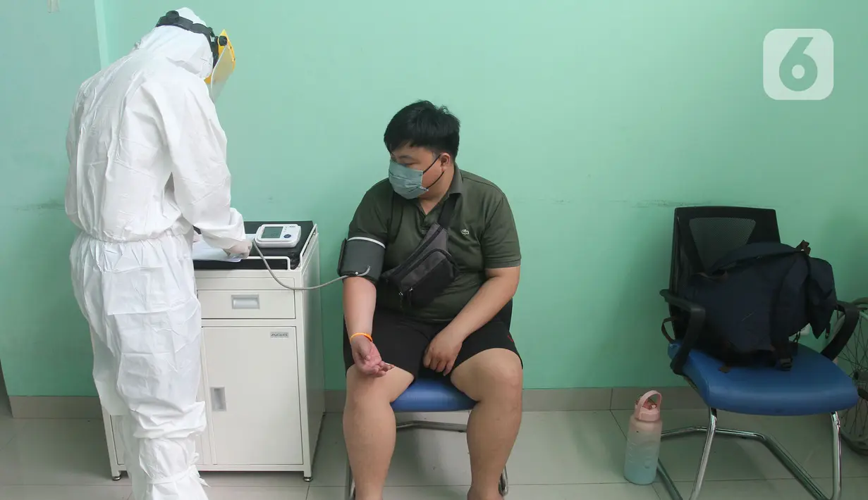 Paramedis mengecek kesehatan pasien positif COVID-19 yang dirawat di Puskesmas Jurumudi, Tangerang, Banten, Kamis (17/2/2022). Kasus positif COVID-19 di Kota Tangerang terus mengalami penurunan kasus dari 2000 kasus perhari menjadi 1000 kasus perhari. (merdeka.com/Arie Basuki)