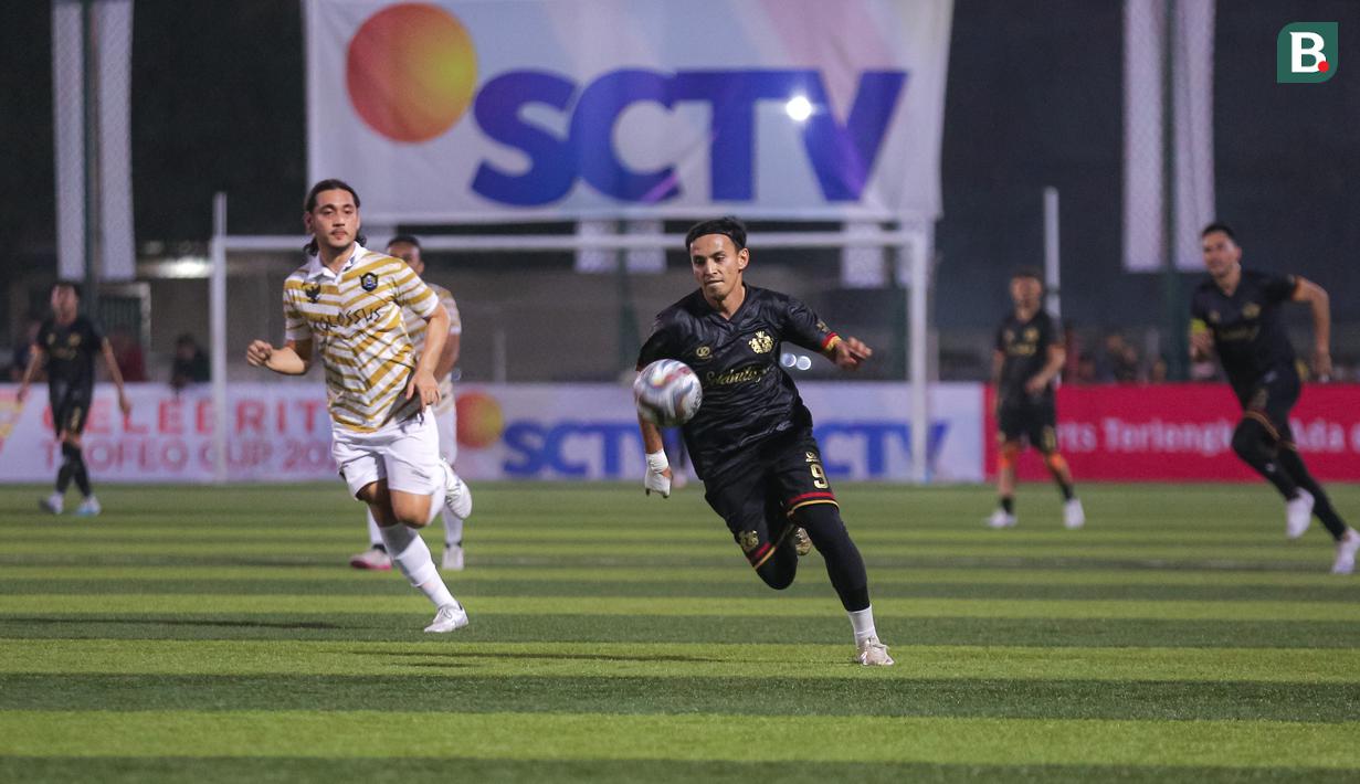 Pemain Selebritas FC, Rifky Alhabsyi (kanan) menggiring bola saat bertanding melawan Colossus FC pada laga Celebrity Trofeo Cup 2023 yang beralangsung di DM Sport, Ciledug, Tangerang, Minggu (29/10/2023). (Bola.com/Bagaskara Lazuardi)