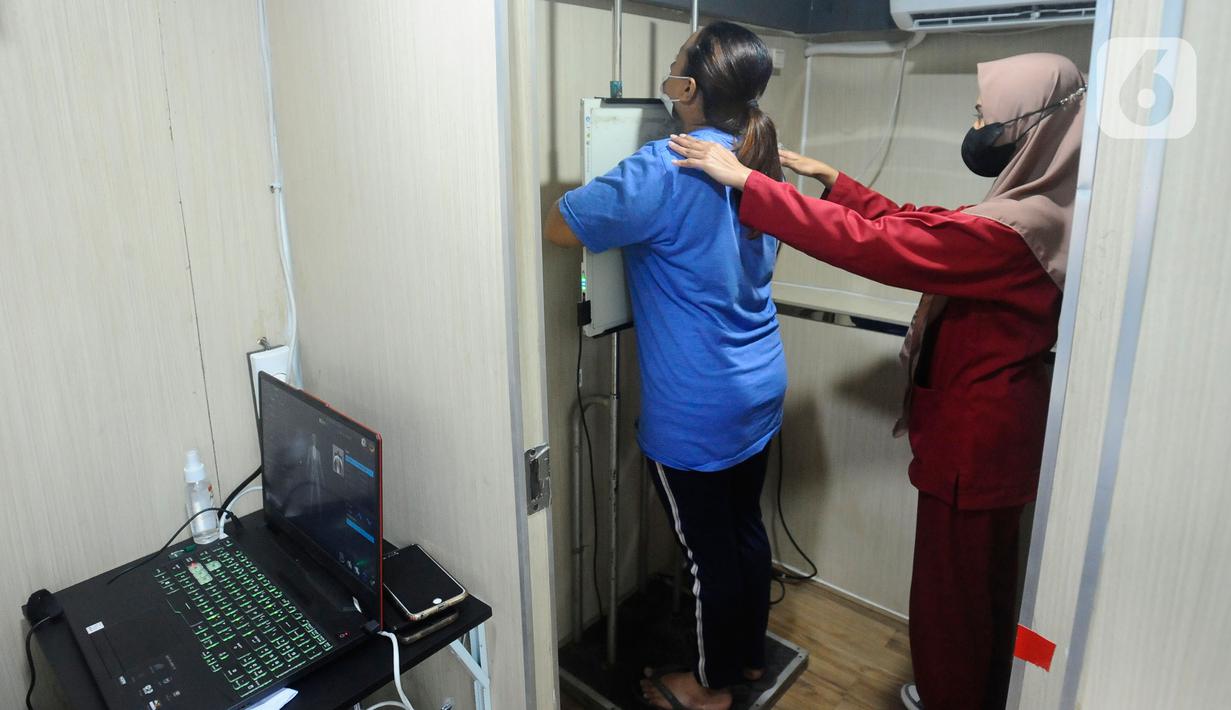 Warga melakukan ronsen pada mobile  X-Ray Artificial Intelligence saat kegiatan skrining penyakit tuberkulosis (TBC) di Kantor Kecamatan Cipayung, Depok, Jawa Barat, Rabu (4/1/2023). Kementerian Kesehatan (Kemenkes) RI melakukan skrining besar-besaran untuk menemukan 500 ribuan orang yang belum diobati dan berisiko menjadi sumber penularan penyakit TBC. (merdeka.com/Arie Basuki)