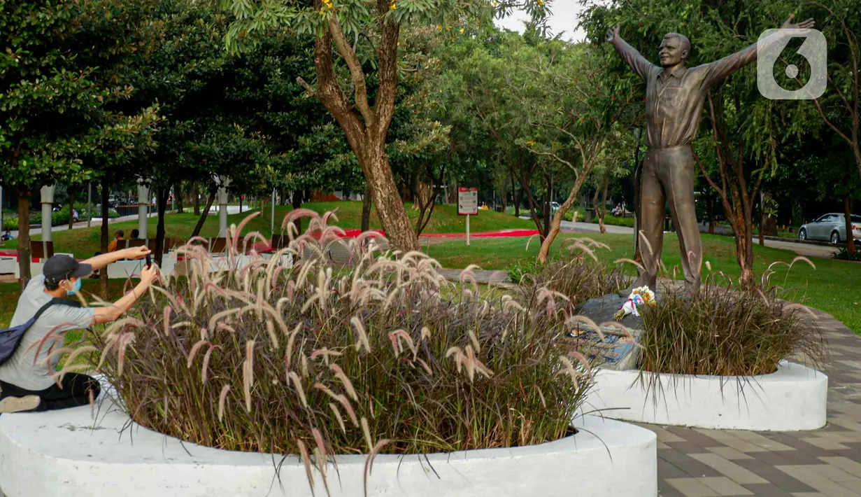 Pengunjung mengambil gambar patung Kosmonaut Rusia, Yuri Alekseyevich Gagarin Yuri Gagarin di Taman Mataram, Kebayoran Baru, Jakarta, Minggu (14/3/2021). Pemerintah Rusia menghadiahkan patung itu kepada pemerintah Indonesia sebagai simbol persahabatan kedua negara. (Liputan6.com/Faizal Fanani)