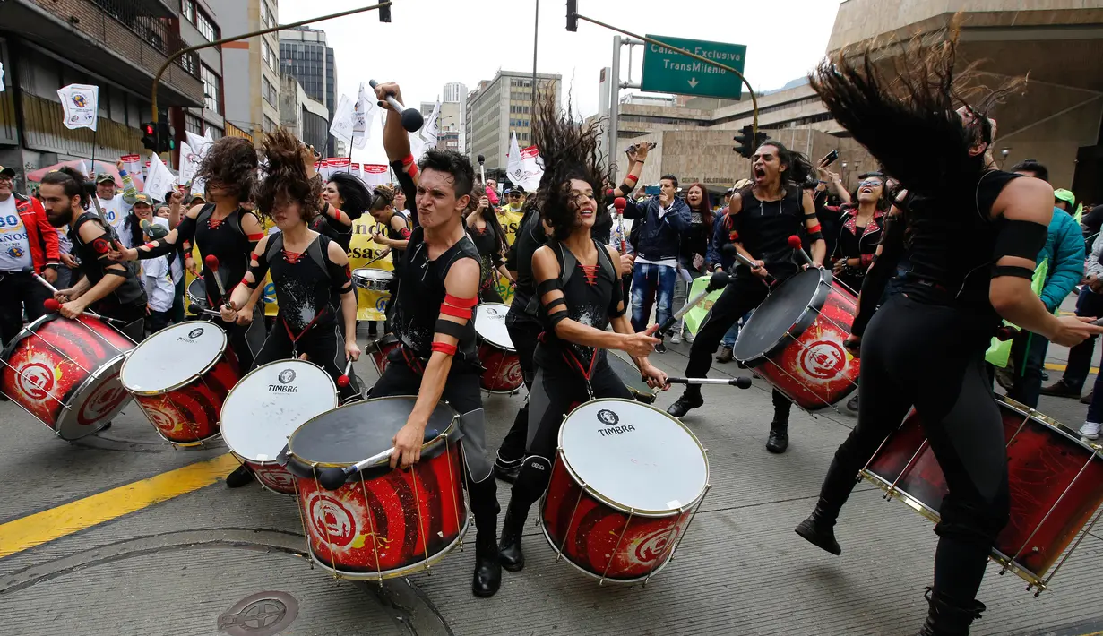 Sejumlah orang memukul alat musik saat melakukan aksi protes pada peringatan Hari Buruh di Bogota, Kolombia (1/5). Mereka melakukan aksi protes selamay peringatan Hari Buruh dengan cara bermain alat musik. (AP/Fernando Vergara)