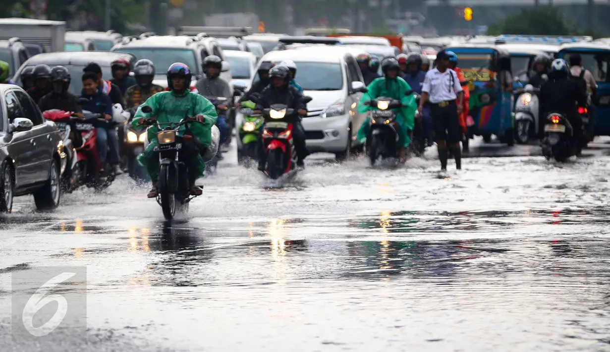 Sejumlah kendaraan melewati genangan air di kawasan Jalan Merdeka Timur, Jakarta, Selasa (1/11). Hujan deras disertai angin yang mengguyur wilayah Jakarta, mengakibatkan genangan di sejumlah ruas jalan. (Liputan6.com/Faizal Fanani)