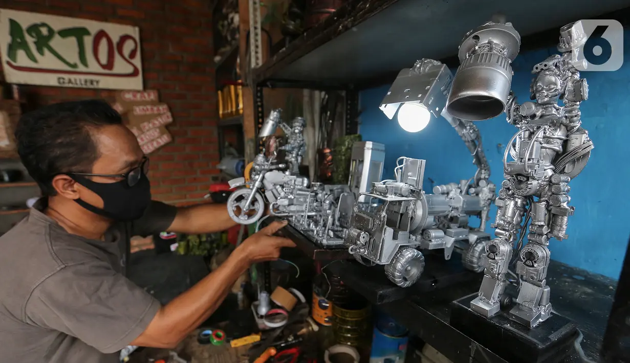 Animator Toto Sihono, merapikan produk berupa pajangan dari limbah komponen elektronik di Galeri Artos Griya Asri Pamulang, Tangerang Selatan, Rabu (16/8/2020). Produk dari limbah elektronik dibentuk menjadi robot, pajangan lampu, mobil-mobilan hingga maket perkotaan. (Liputan6.com/Fery Pradolo)
