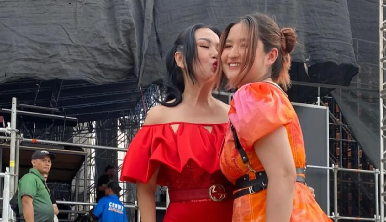 <p>Berduet dengan sang putri di atas panggung, Titi DJ mengenakan gaun serupa berwarna merah [instagram/hitcjakarta]</p>