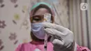 Petugas kesehatan saat mengisi serum vaksin ke dalam jarum suntik di Puskesmas Kecamatan Cilincing, Jakarta, Selasa (23/2/2021). Pemerintah juga melakukan vaksinasi tahap dua untuk petugas pelayanan publik karena dianggap rentan terpapar Covid-19. (merdeka.com/Iqbal S. Nugroho)