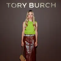 Amanda Seyfried hadir dengan koleksi Resort 2027. Padanan brushed wool top, patent leather skirt, woven raffia belt, dengan the suede Bunny Knot shoulder bag, dan peep-toe pumps. / Foto: Tory Burch.