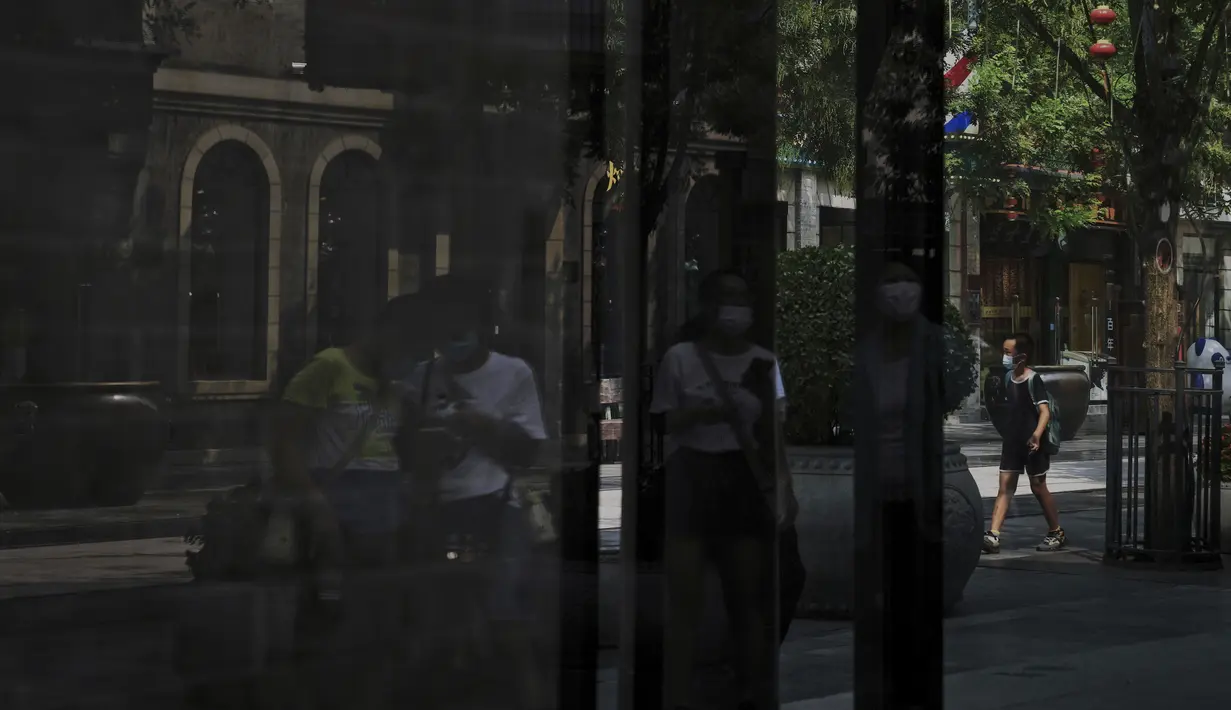 <p>Pengunjung yang mengenakan masker berjalan melewati pertokoan kosong di Qianmen Street di Beijing, Rabu, 17 Agustus 2022. Pabrik-pabrik di barat daya China telah ditutup dan sebuah kota memberlakukan pemadaman bergilir setelah waduk yang digunakan untuk menghasilkan tenaga air mulai menipis akibat kekeringan yang memburuk, menambah ketegangan ekonomi pada suatu waktu ketika Presiden Xi Jinping mencoba untuk memperpanjang posisinya dalam kekuasaan. (AP Photo/Andy Wong)</p>
