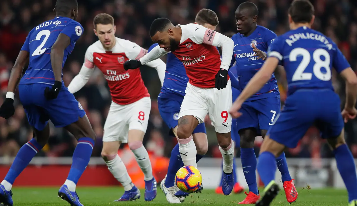 Striker Arsenal, Alexandre Lacazette berusaha membawa bola melewati pemainnya Chelsea saat bertanding pada lanjutan Liga Inggris di stadion Emirates di London (19/1). Arsenal menang 2-0 atas Chelsea. (AP Photo/Frank Augstein)