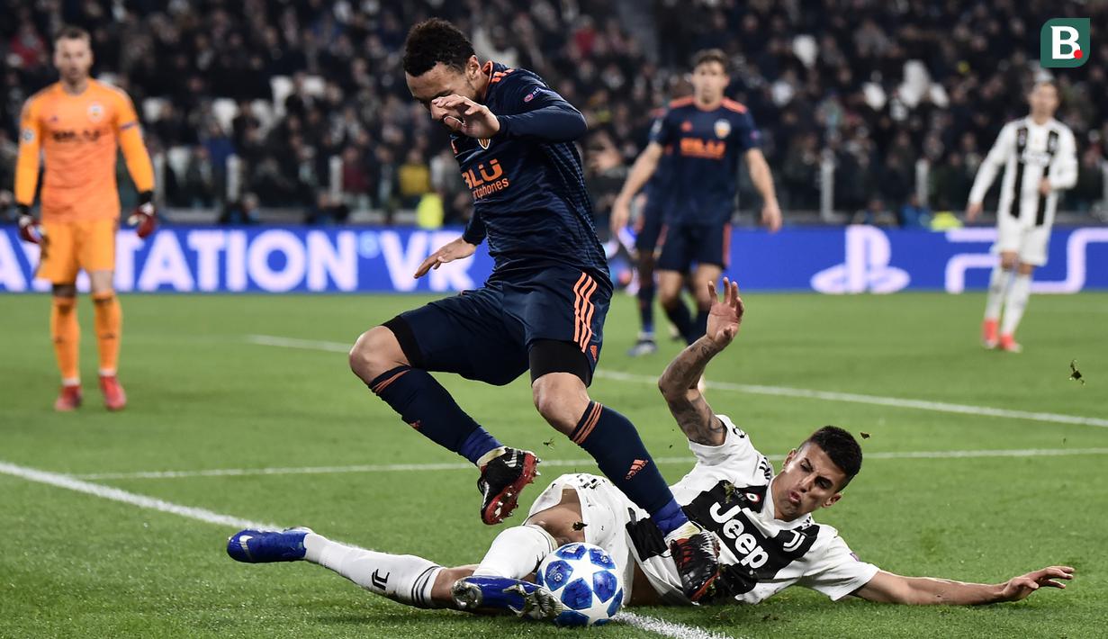 Bek Juventus, Joao Cancelo, menekel gelandang Valencia, Francis Coquelin, pada laga Liga Champions di Stadion Allianz, Turin, Selasa (27/11). Juventus menang 1-0 atas Valencia. (AFP/Marco Bertorello)