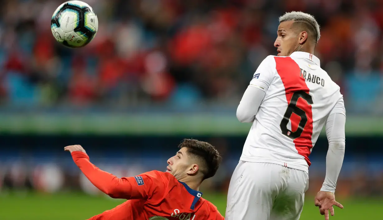 Gelandang timnas Cile, Angelo Sagal berebut bola dengan bek timnas Peru, Miguel Angel Trauco pada semifinal Copa America 2019 di Arena do Gremio, Kamis (4/7/2019) pagi. Peru lolos ke final Copa America 2019 setelah mengalahkan juara bertahan, Cile, dengan skor 3-0. (AP/ Silvia Izquierdo)