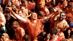 Para peserta menikmati butiran-butiran tomat dalam festival La Tomatina di desa Bunol, Spanyol, Rabu (30/8). Adu lempar tomat ini sudah dilakukan sejak 1945 oleh sekelompok anak-anak di daerah penghasil tomat Kota Valencia, Spanyol. (Alberto Saiz/AP)