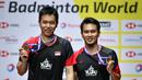 Pasangan Indonesia, Hendra Setiawan/Mohammad Ahsan melakukan selebrasi usai menjuarai Kejuaraan Dunia Bulutangkis 2019 setelah mengalahkan wakil Jepang, Takuro Hoki/Yugo Kobayashi, Minggu (25/8). Indonesia menang 25-23, 9-21, 21-15. (AFP/Fabrice Coffrini)