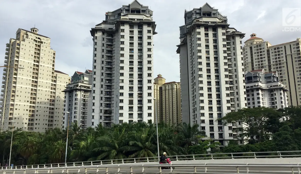 Seorang pengendara sepeda motor melintasi jembatan layang dengan latar belakang gedung apartemen yang berjajar di kawasan Kemayoran, Jakarta, Jumat (19/1). (Liputan6.com/Immanuel Antonius)