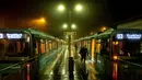 Seorang perempuan berjalan menjauh dari stasiun kereta bawah tanah saat hujan di Oberursel dekat Frankfurt, Jerman, pada 12 November 2020, ketika jumlah infeksi covid-19 melebihi 20.000 lagi.  (AP Photo/Michael Probst)