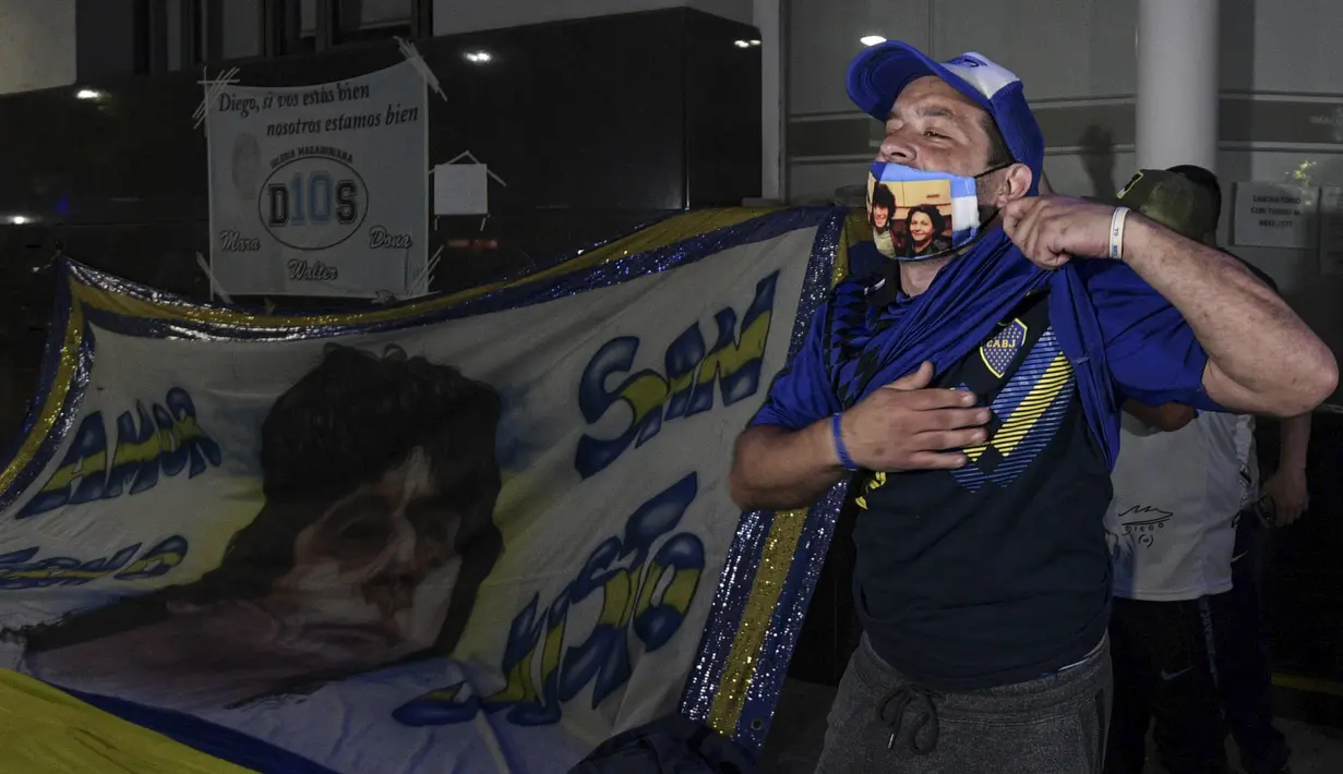 Penggemar mantan bintang sepak bola Argentina, Diego Maradona berkumpul di luar rumah sakit tempatnya akan menjalani operasi di Olivos, Buenos Aires, Selasa (3/11/2020). Diego Maradona menjalani operasi hematoma subdural atau pembekuan darah di otak. (JUAN MABROMATA / AFP)