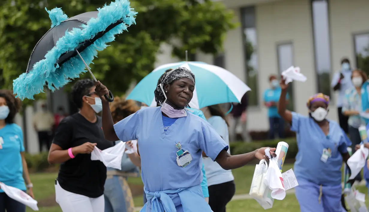 Petugas medis menari sebagai penghargaan atas perawatan untuk pasien COVID-19 di luar New Orleans East Hospital, New Orleans, Amerika Serikat, 15 Mei 2020. Serenade stimulus ini untuk memberikan dukungan moral kepada petugas medis dan pasien COVID-19. (AP Photo/Gerald Herbert)