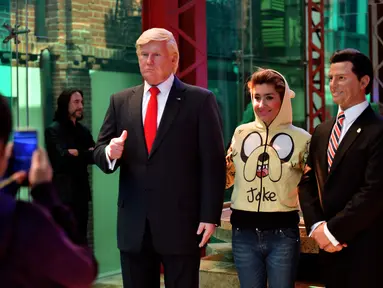 Seorang pengunjung berpose di dekat Patung lilin Presiden AS Donald Trump di Museum Lilin di Mexico City, Selasa (31/1). (AFP PHOTO / Yuri CORTEZ)