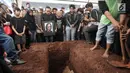 Keluarga dan kerabat berdoa di dekat makam Yon Koeswoyo di TPU Tanah Kusir, Jakarta Selatan, Sabtu (6/1).  Yon Koeswoyo dimakamkan bersama dengan almarhum kakaknya Tonny Koeswoyo. (Liputan6.com/Arya Manggala)