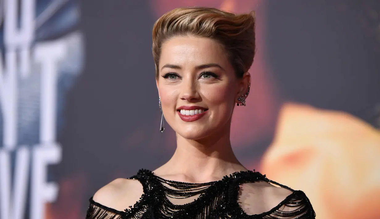 Aktris Amber Heard tersenyum saat menghadiri pemutaran perdana film produksi Warner Bros 'Justice League' di Teater Dolby di Hollywood, California, AS (13/11). Amber Heard tampil seksi dengan gaun jaring-jaring hitam transparan. (AFP Photo/Robyn Beck)