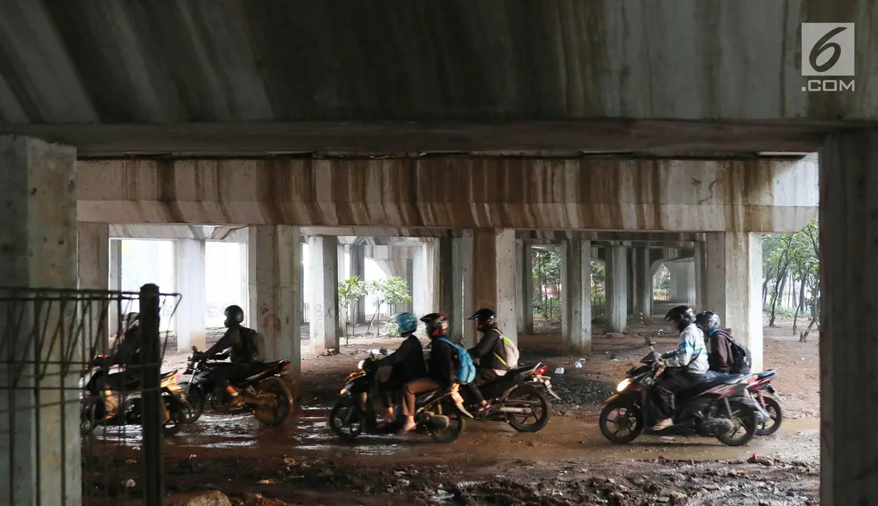 Pengendara motor melintasi jalan setapak di kolong tol di kawasan Lebak Bulus, Jakarta, Selasa (13/2). Untuk menghindari macet sebagian pengendara memanfaatkan jalan setapak tersebut untuk memersingkat waktu tempuh. (Liputan6.com/Immanuel Antonius)