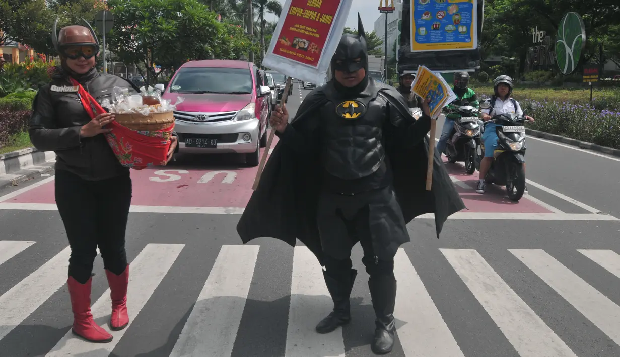 Warga mengenakan kostum superhero Gundala dan Batman saat melakukan aksi sosialisasi pencegahan virus corona di Solo, Rabu (4/3/2020). Aksi juga mengajak masyarakat menjaga kebersihan dan kesehatan dengan menerapkan pola hidup sehat. (AFP Photo/Anwar Mustafa)
