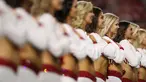 Cheerleaders dari tim Arizona Cardinals mendengarkan lagu kebangsaan sebelum pertandingan NFL melawan Oakland Raiders di University of Phoenix Stadium di Glendale, Arizona (12/8). (Christian Petersen / Getty Images / AFP)