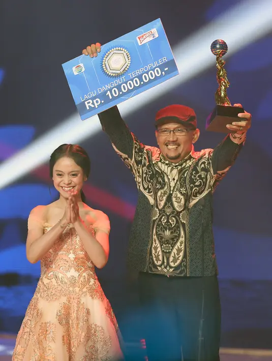 Ekspresi juga ditunjukkan ketika pencipta lagu yang dibawakan berjudul Egois mendapat penghargaan Lagu Dangdut Terpopuler. Hendro Saki mengangkat trofi dan hadiah setelah dinobatkan sebagai pemenangnya. (Bambang E. Ros/Bintang.com)
