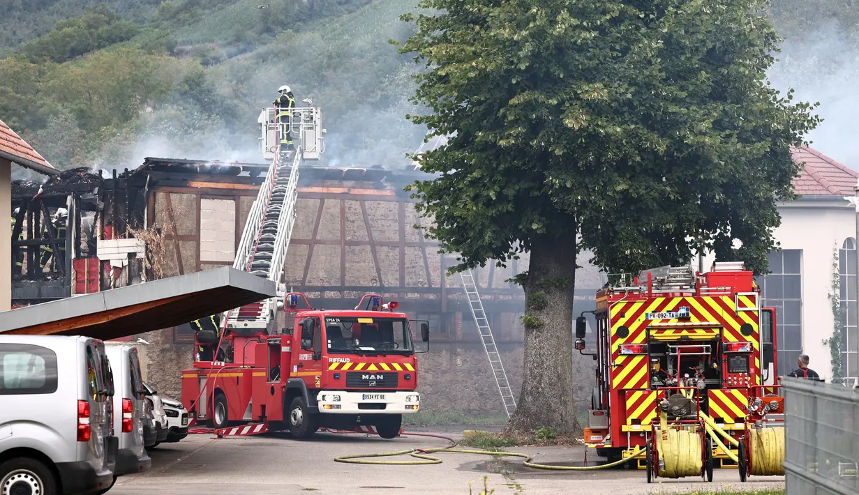 Petugas pemadam kebakaran bekerja memadamkan api setelah kebakaran di sebuah rumah penyandang disabilitas di Wintzenheim dekat Colmar, Prancis timur, pada 9 Agustus 2023. (AFP/Sébastien Bozon)