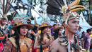 Sejumlah orang mengenakan pakaian adat melakukan pawai festival Budaya Borneo di Car Free Day, Jakarta, Minggu (30/7). Festival tersebut dalam rangka mengenalkan adat dan budaya borneo melalui pakaian dan musiknya. (Liputan6.com/Helmi Afandi)