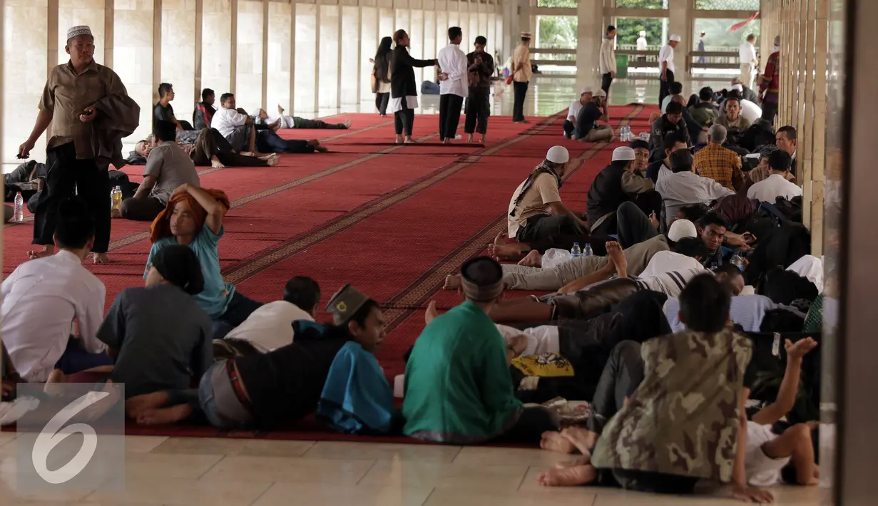 Peserta aksi damai 212 beristirahat di sekitar Masjid Istiqlal, Jakarta, Kamis (1/12). Rencananya, ratusan ribu umat Islam akan melakukan aksi super damai 212 di halaman Monumen Nasional Jakarta. (Liputan6.com/Helmi Fithriansyah)