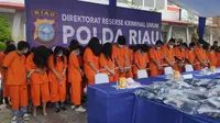 Puluhan tersangka operator judi online yang ditangkap Polda Riau di sebuah ruko di Pekanbaru. (Liputan6.com/M Syukur)