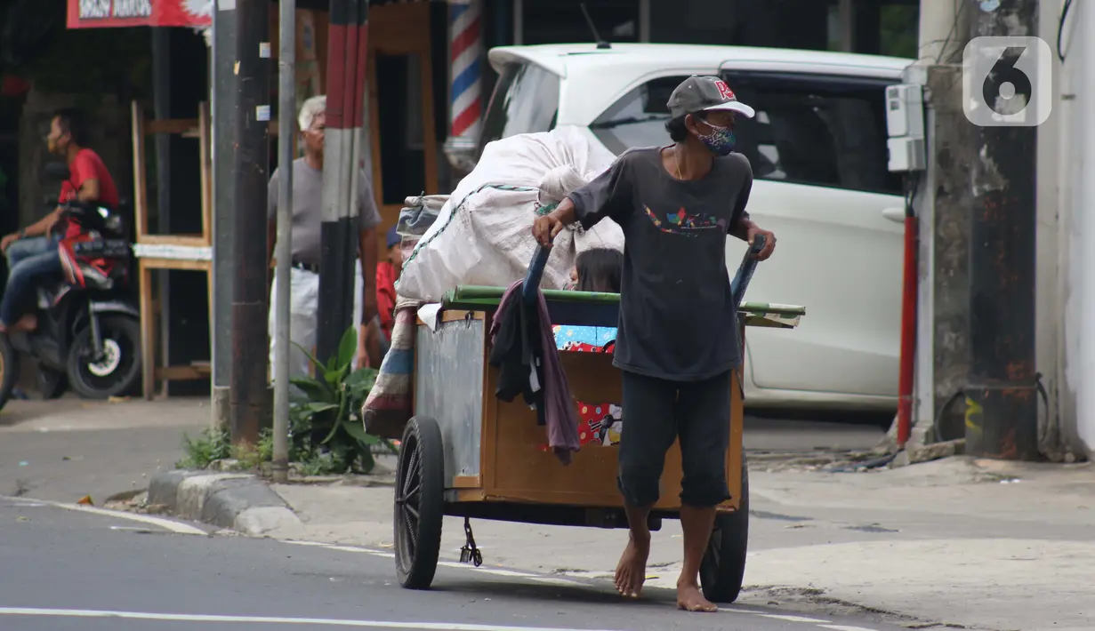 Pemulung melintas di Jalan Raden Saleh, Jakarta, Kamis (30/4/2020). Setiap Ramadan tiba, kemunculan pemulung yang membawa gerobak marak terjadi. Saat ini, kemunculan mereka menjadi masalah tersendiri di tengah upaya memutus mata rantai penyebaran Covid-19. (Liputan6.com/Helmi Fithriansyah)