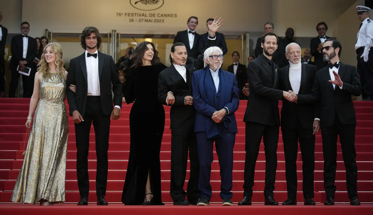 <p>Johnny Depp berhenti untuk memberi tanda tangan dan berpose selfie dengan penggemar sebelum sampai ke karpet merah. Dia dan pemeran dan kru 'Jeanne Du Barry' berpose bersama bergandengan tangan. (AP Photo/Daniel Cole)</p>