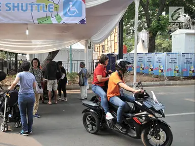 Pengunjung menggunakan jasa Ojek Disabilitas saat hendak menyaksikan pertandingan Asian Para Games 2018 di Gelora Bung Karno, Jakarta, Rabu (10/10). INAPGOC menyediakan sekitar 35 armada Ojek Disabilitas secara gratis. (Merdeka.com/Iqbal S. Nugroho)
