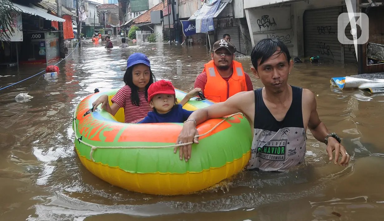 Petugas mengevakuasi anak-anak korban banjir menggunakan perahu karet di kawasan Karet Pasar Baru Barat, Jakarta, Selasa (25/2/2020). Banjir yang terjadi sejak subuh akibat luapan Kanal Banjir Barat tersebut merendam ratusan rumah hingga setinggi dua meter. (merdeka.com/Arie Basuki)